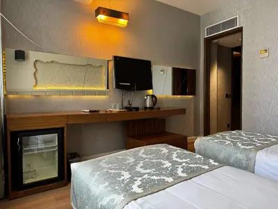 a hotel room with two beds and a television at Style Star Hotel Cihangir in Istanbul