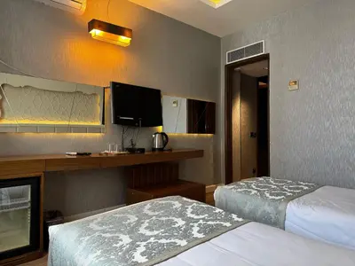 a hotel room with two beds and a television at Style Star Hotel Cihangir in Istanbul