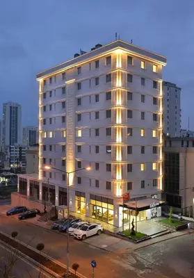 a large white building with cars parked in a parking lot at Nish Palace Exlusive Suites in Istanbul