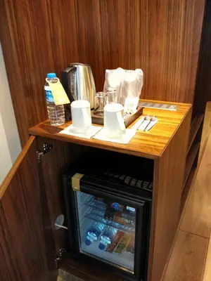 a small wooden table with a refrigerator in a room at The White Orient Hotel in Istanbul