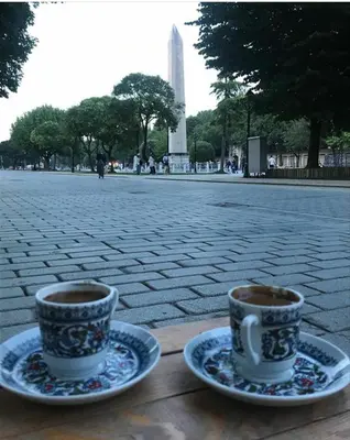 two cups of coffee sitting on plates in front of the washington monument at Optimist Hotel in Istanbul