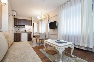a living room with a white table and a kitchen at Résidence Le Rêve in Istanbul