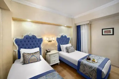 a bedroom with two beds with blue headboards at Ayasultan Hotel in Istanbul
