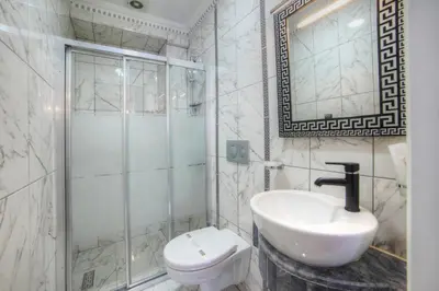 a white bathroom with a sink and a toilet at Ayasultan Hotel in Istanbul