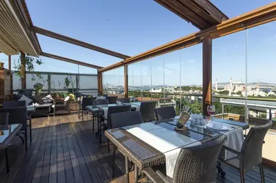 a restaurant with tables and chairs and large windows at Burckin Hotel in Istanbul