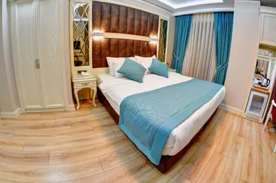 a bedroom with a large bed with blue pillows at Novelty Hotel in Istanbul