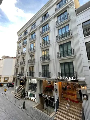 a large white building with a store front at Novelty Hotel in Istanbul