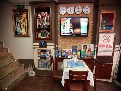 a dining room with a table and a tv on the wall at Arife Sultan Hotel in Istanbul