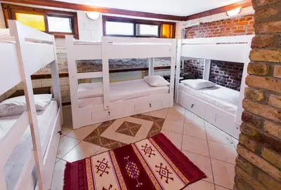 a room with four bunk beds and a brick wall at Cheers Vintage Hostel in Istanbul