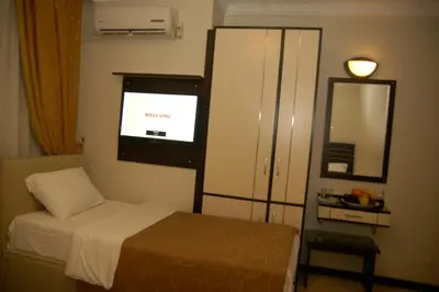 a small bedroom with a bed and a mirror at Merdan Hotel in Istanbul