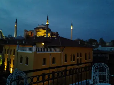 a building with a mosque with two towers at night at Berk Guest House - Grandma's House in Istanbul