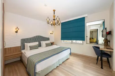 a bedroom with a bed and a desk and a television at The Marions Suite istanbul Special Category Taksim in Istanbul