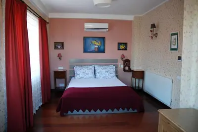 a bedroom with a bed and red curtains at L'isola Guesthouse in Heybeliada