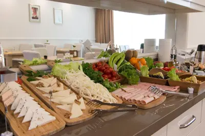 a buffet of vegetables and meats on a counter at Goldhan Hotel in Tekirdag