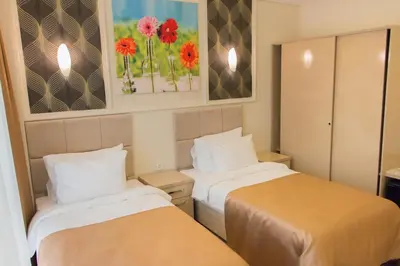 two beds in a room with flowers on the wall at Goldhan Hotel in Tekirdag