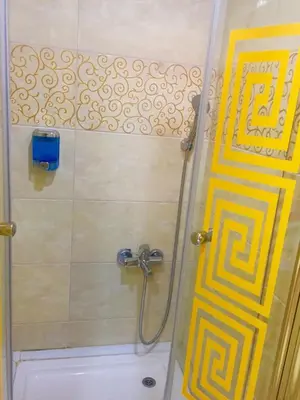 a shower with a yellow door in a bathroom at ARINÇ HOTEL in Istanbul