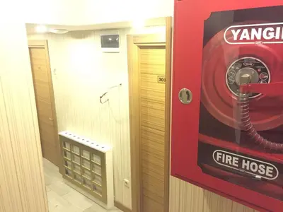 a fire hose dispenser in a room with a fire house at ARINÇ HOTEL in Istanbul