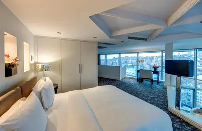 a hotel room with a bed and a flat screen tv at The Elysium Taksim in Istanbul