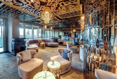 a lobby with couches and chairs and a wall of windows at The Elysium Taksim in Istanbul