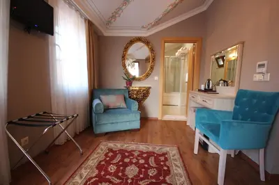 a living room with two blue chairs and a mirror at Sultans Royal Hotel in Istanbul