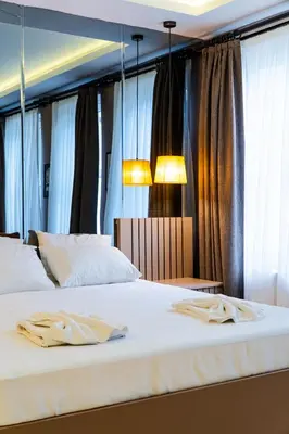 two beds in a bedroom with two lamps and curtains at Cheers Porthouse in Istanbul