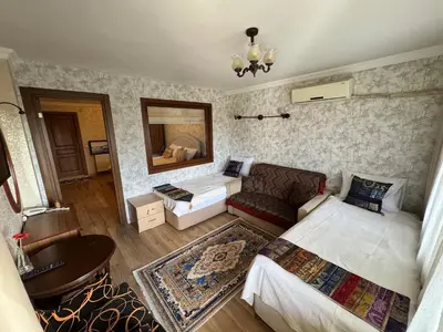 a room with two beds and a couch and a mirror at Hotel Ipekyolu in Istanbul