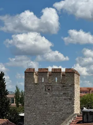a tall brick building with a cloudy sky in the background at Hotel Ipekyolu in Istanbul