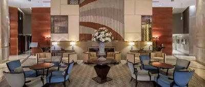 a lobby with tables and chairs and a vase of flowers at Hilton Bursa Convention Center & Spa in Bursa