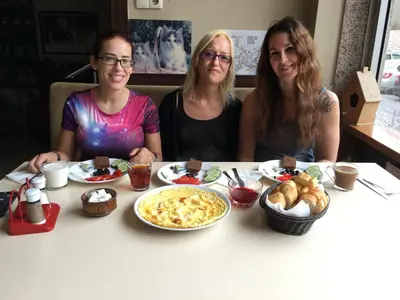 three women sitting at a table with food at Second Home Suites in Istanbul