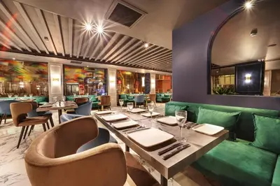 a restaurant with a green couch and tables and chairs at Concept Nisantasi Hotels & Spa in Istanbul