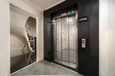 a hallway with a black door and a staircase at Deluxe Newport Hotel - Old City in Istanbul