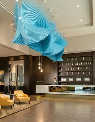 a large blue sculpture hanging from the ceiling in a hotel lobby at Centro Westside by Rotana in Istanbul