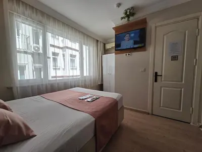 a bedroom with a bed and a tv on the wall at TAKSİM LİFE HOUSE in Istanbul