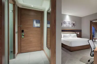 a bedroom with a bed and a wooden door at Hampton By Hilton Bursa in Bursa