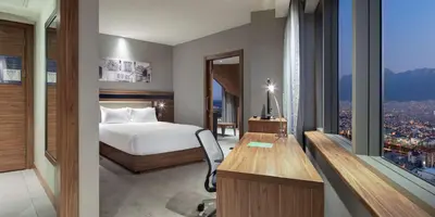 a hotel room with a bed and a desk and a window at Hampton By Hilton Bursa in Bursa