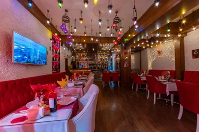 a restaurant with white tables and red chairs at Charm Hotel in Istanbul