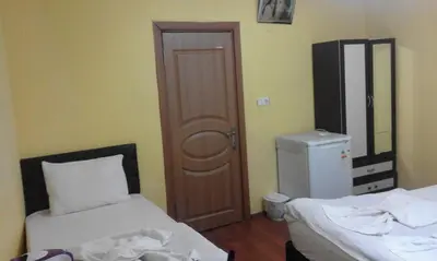 a small room with two beds and a door at Bereket traveler Hotel in Istanbul