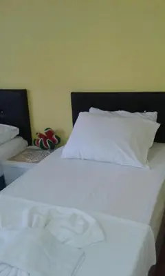 a white bed with a black headboard and white sheets at Bereket traveler Hotel in Istanbul