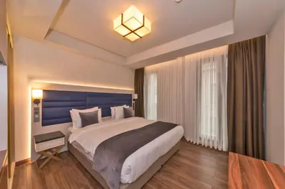 a bedroom with a large bed with a blue headboard at Golden Royal Hotel & SPA in Istanbul