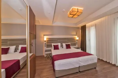 a hotel room with two beds and a mirror at Golden Royal Hotel & SPA in Istanbul