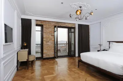 a bedroom with a white bed and a brick wall at Georges Hotel Galata in Istanbul
