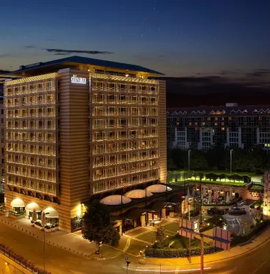 a large hotel building at night in a city at Divan Istanbul in Istanbul