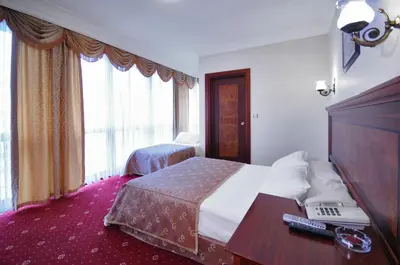 a hotel room with a bed and a desk with a laptop at Grand Eyuboglu Hotel in Istanbul