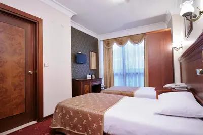 a hotel room with two beds and a window at Grand Eyuboglu Hotel in Istanbul