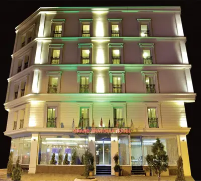 a large white building with a store front at night at Grand Anatolia Hotel in Istanbul