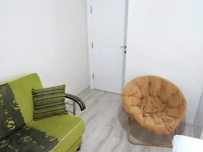 a living room with a green couch and a chair at Istanberry - Paradise Apartments in Istanbul
