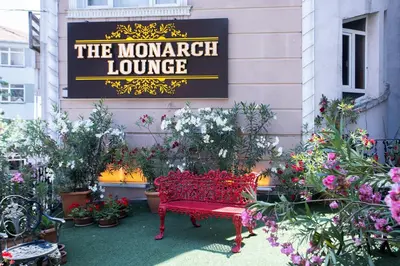 a red bench in front of a sign with plants at Balin Hotel - Special Category in Istanbul