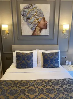 a bed in a hotel room with a picture of a woman at 12 rooms hotel in Köseilyas