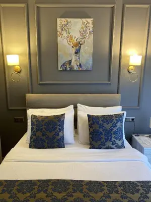 a bedroom with a bed with a deer painting on the wall at 12 rooms hotel in Köseilyas