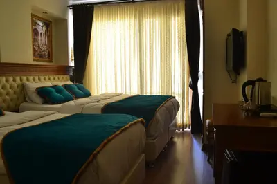 a hotel room with two beds and a window at Blue Istanbul Hotel in Istanbul